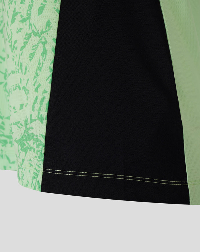 Side view of mint green patterned training tee featuring a black side panel and contrast double stitching at the hem.