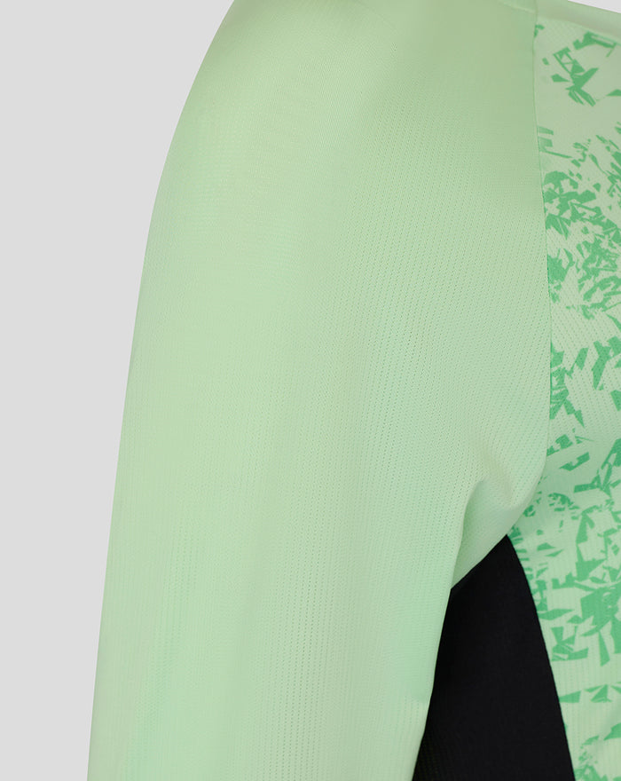 Close-up of a mint green sleeve with a contrasting patterned side panel on the training T-shirt.