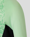 Shoulder and chest area of mint green training midlayer top with patterned panel and black underlay.