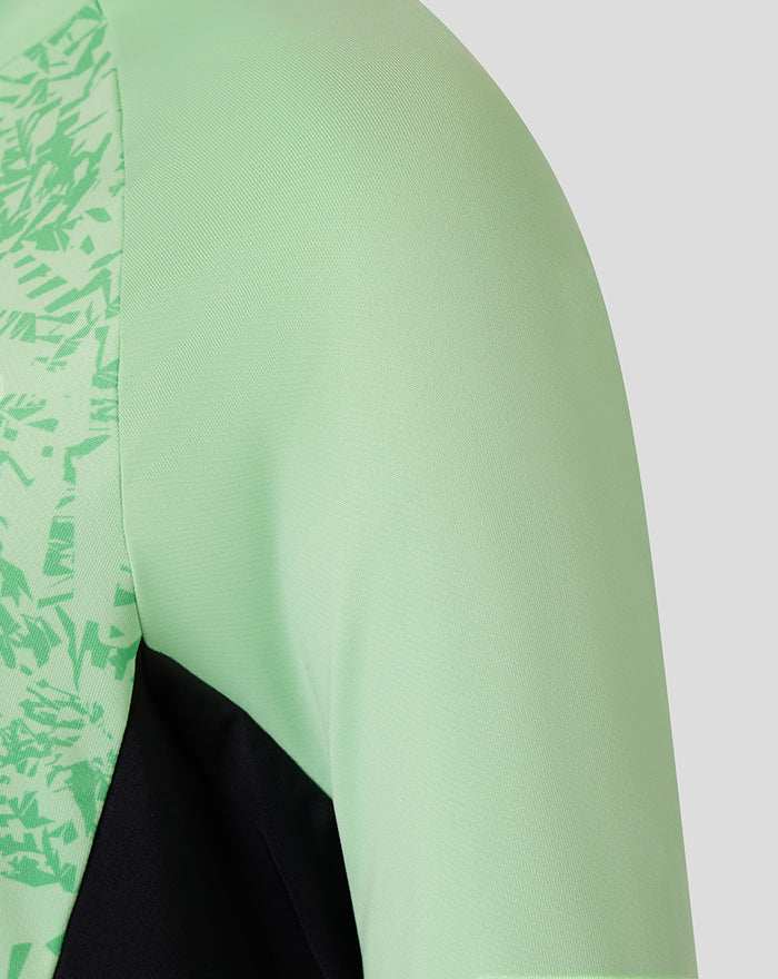 Shoulder and chest area of mint green training midlayer top with patterned panel and black underlay.