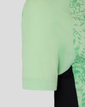 Close up of mint green training T shirt sleeve hem and side panel with textured fabric and continued pattern