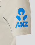 Beige short sleeve shirt with blue ANZ logo on the sleeve