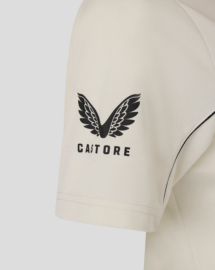 Close up of the polo showing a black wing logo on the left chest and a Castore label along the collar seam