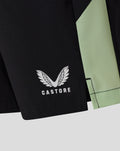 Close-up of black junior training shorts with white Castore logo and mint green side panel.