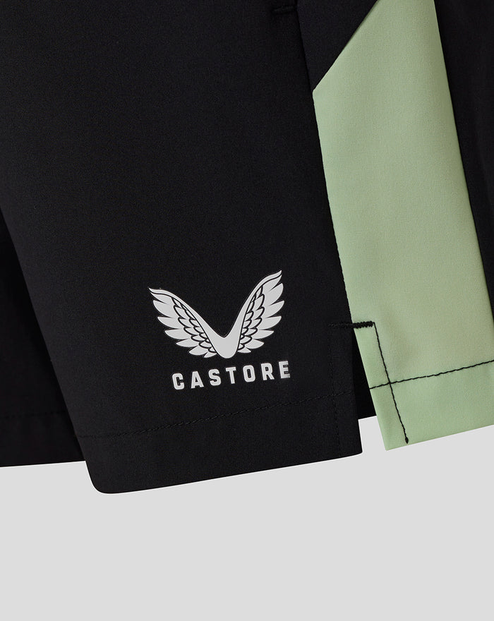 Close-up of black junior training shorts with white Castore logo and mint green side panel.