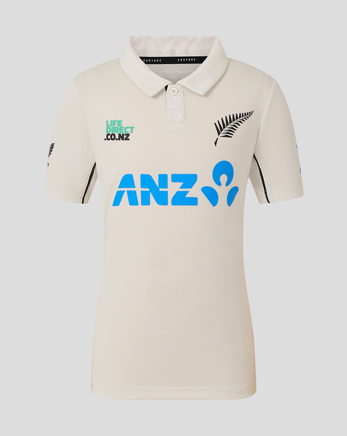 Junior beige polo shirt with blue ANZ logo across the chest and a fern emblem