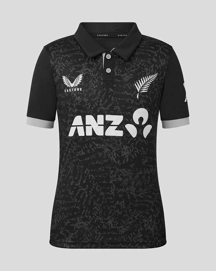 Front view of junior black ODI short sleeve polo shirt with an abstract pattern and white sponsor logos.