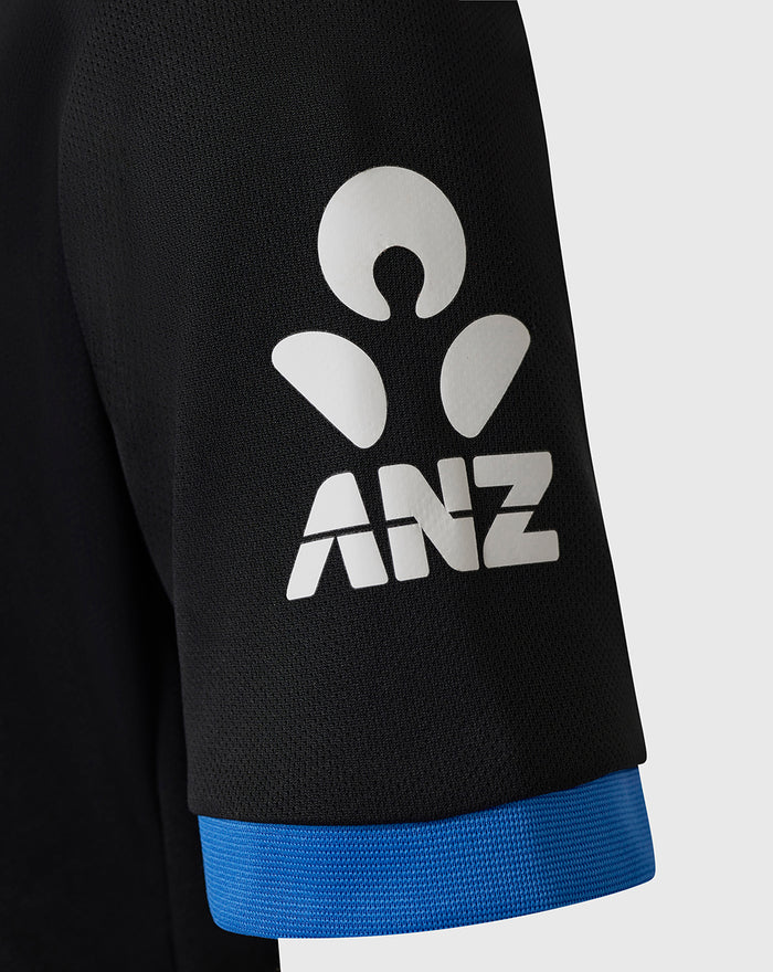 Close up of black sleeve with white ANZ logo and blue cuff.