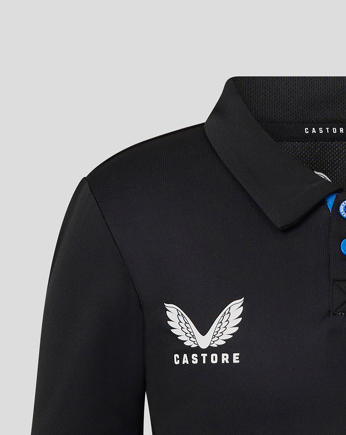 Close up of the upper front of a black junior T20 polo showing the Castore wing logo on the chest and blue button placket