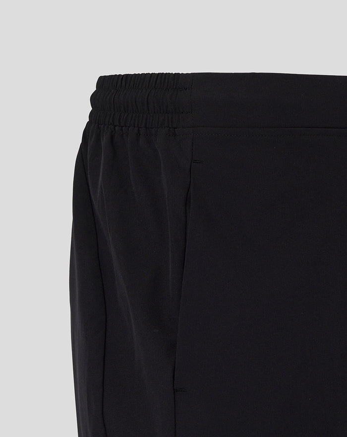Close up of the elastic waistband and side seam of black training shorts.