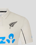 Cream short sleeve polo shirt with black fern logo on the left chest and blue graphic motifs.