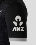 Sleeve close up featuring ANZ logo on black fabric with a light gray cuff