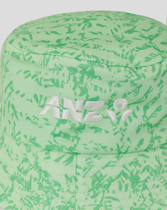 Close-up of lime green camo bucket hat showing embroidered fern emblem and white lettering