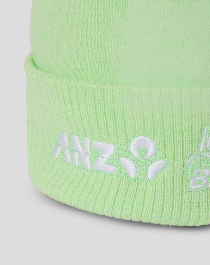Close-up of the lime green knit hat showing white embroidered branding along the cuff
